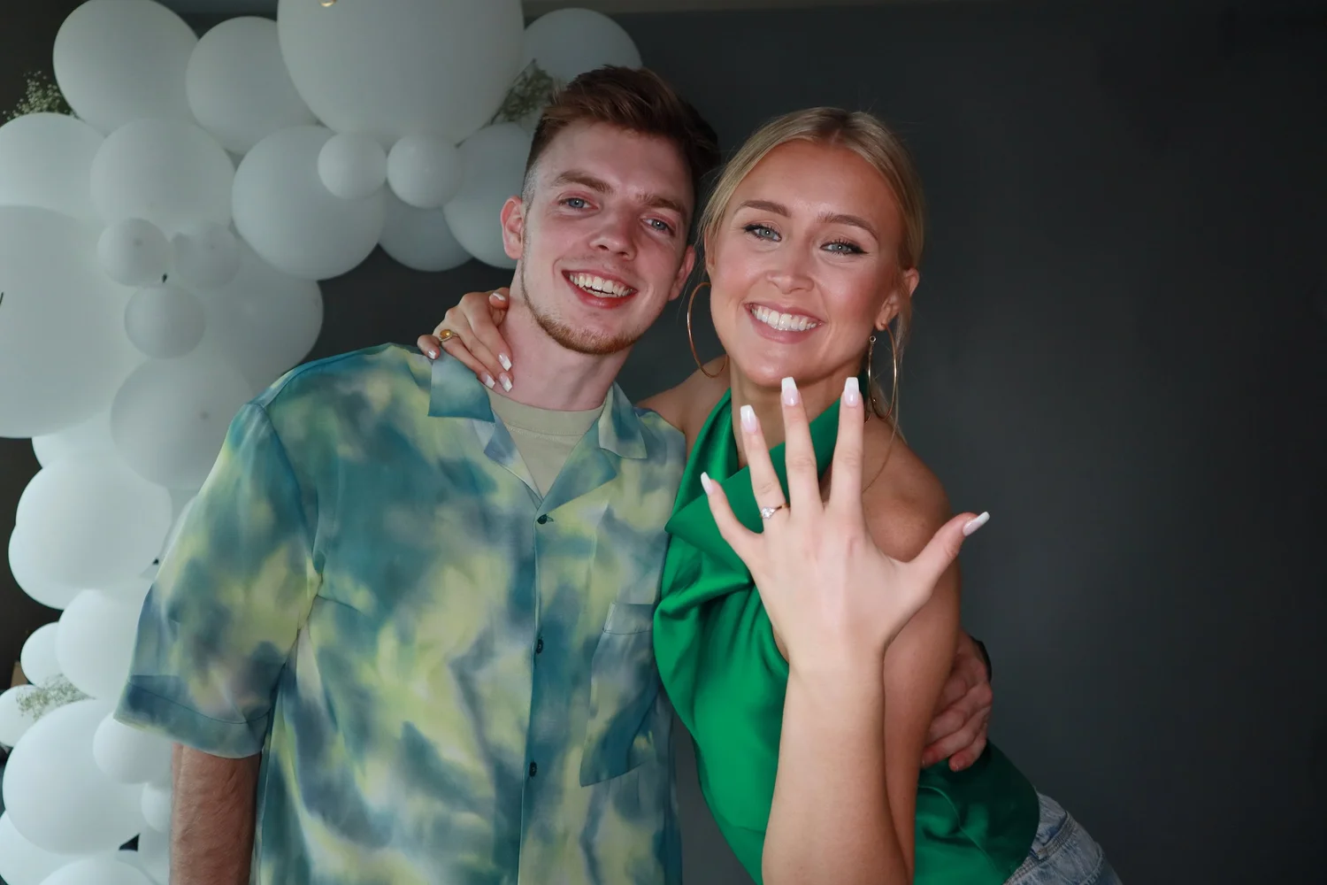 A joyful couple celebrating their engagement at a Memories Matter photobooth
