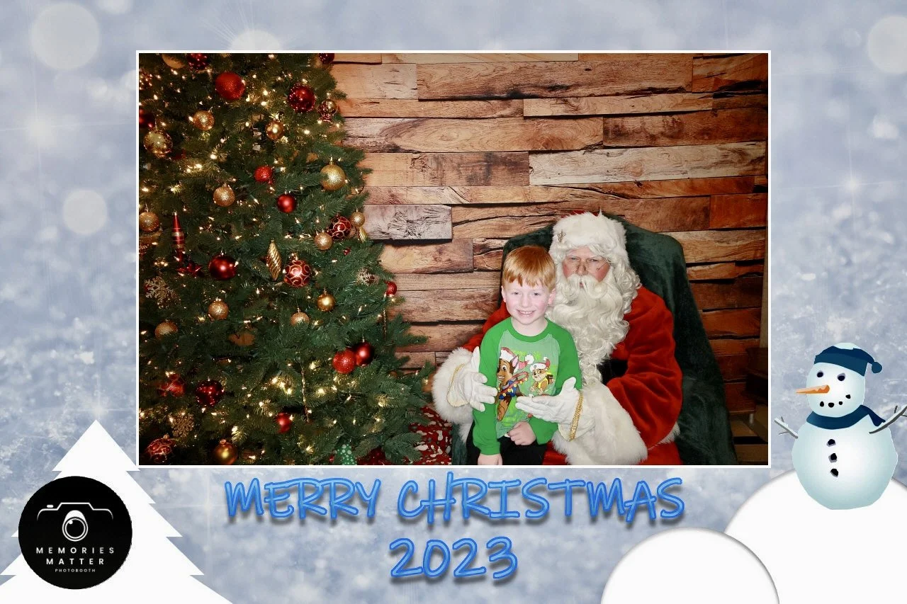 A family smiling with Santa at a Merry Christmas photobooth in Kingsport